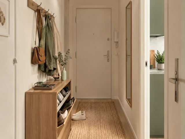 Schmaler, gut organisierter Flur mit Stauraum für Schuhe und Jacken